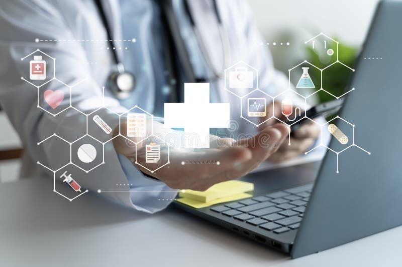 Arzt hält ein digitales Gesundheitskreuz vor einem Laptop mit Medizinsymbolen